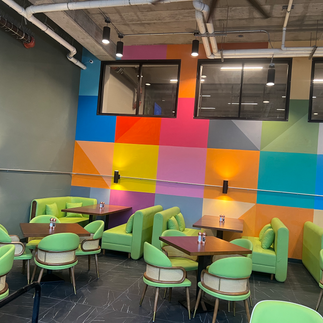 Vibrant restaurant interior with colorful geometric wall and green seating salt lake city dining spots