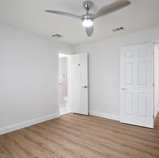 Empty room with light wood floor, white walls, and ceiling fan
