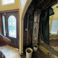 House interior with severe wall damage and construction debris