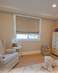 Neutral Roman shade with matching valance in Prosper nursery
