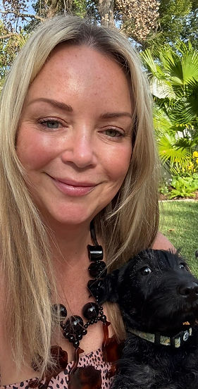 Owner of a luxury home-based small dog boarding and daycare in Murray Hill, Jacksonville, Florida, holding a happy dog in the garden