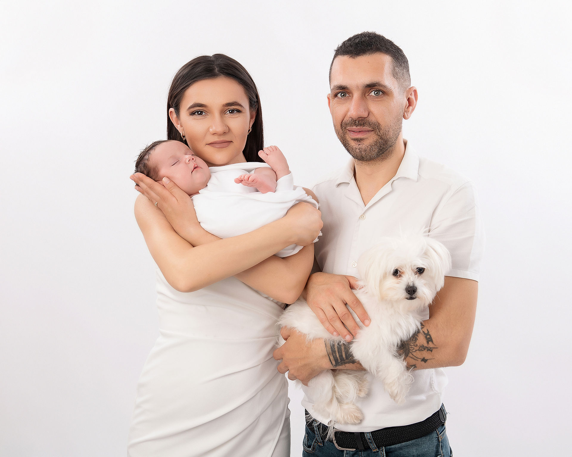 Family portrait of mom, dad, newborn and pet dog