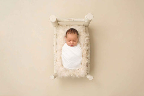Image of newborn baby sleeping on a bed