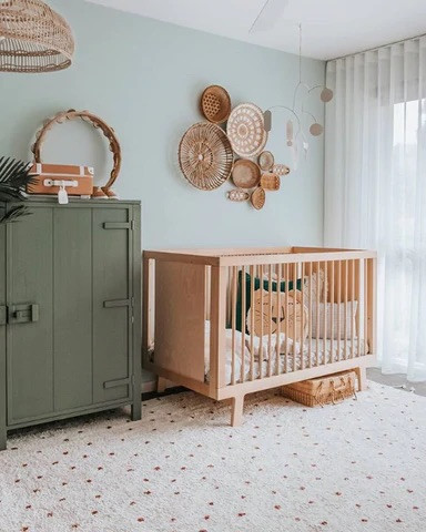 Baby nursery. Wooden cot. Green baby nursery. Rattan wall art