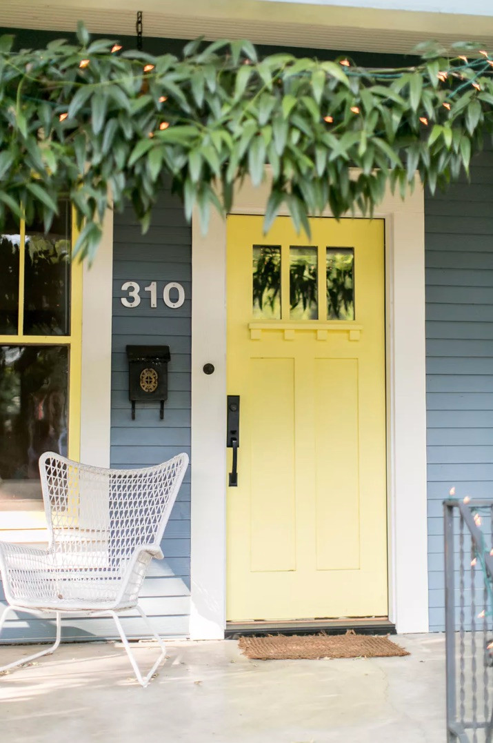 Interior design studio | Interior design blog | Interior designer | Yellow front door with green overhanging foliage. Fairy light foliage.