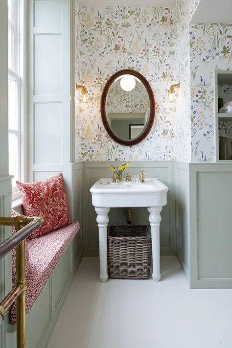 Nature inspired wallpaper complements the sage green panelling beautifully in this bathroom. The symmetry of the brass wall lights adds a real Regency feel to the decor.