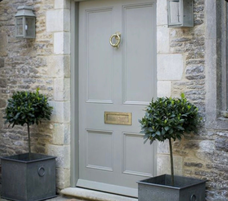 Standard buxus in symmetrical pots, neutral grey and symmetrical outdoor lighting create a beautiful entryway.