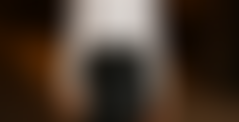 Mujer con falda corta de cuero y blusa blanca, look arreglado y sexy para la noche.