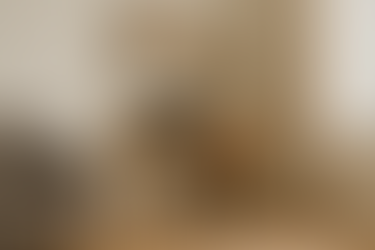 Escritorio pequeño con silla y estantes en la esquina de un salón moderno.