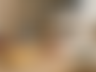 Espacio de costura con máquina blanca, telas y hilos organizados en mesa de madera.