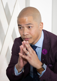 Ink2Scalp client in a purple suit with hands clasped, showing clean and natural scalp micropigmentation results.
