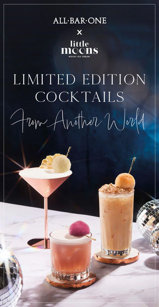 Two cocktails with elegant garnishes on a table.