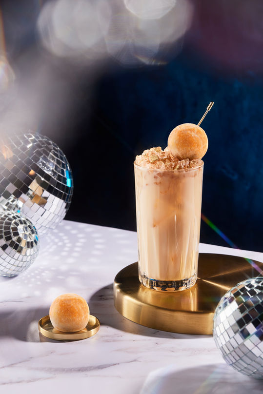 Tall drink with whipped cream and a garnish.