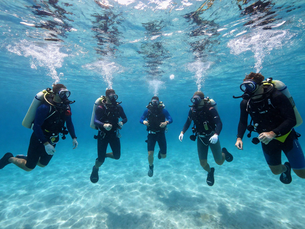 Group of divers exploring clear ocean waters during SNUBA diving in Curaçao experience