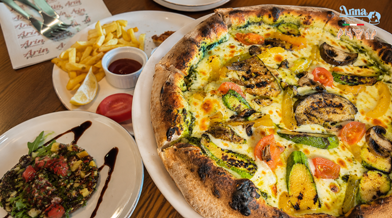 Authentic wood-fired pizza in Saudi Arabia topped with fresh vegetables and baked using traditional Italian techniques