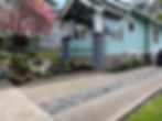 Rain chain into driveway front yard landscape with ribbon driveway.