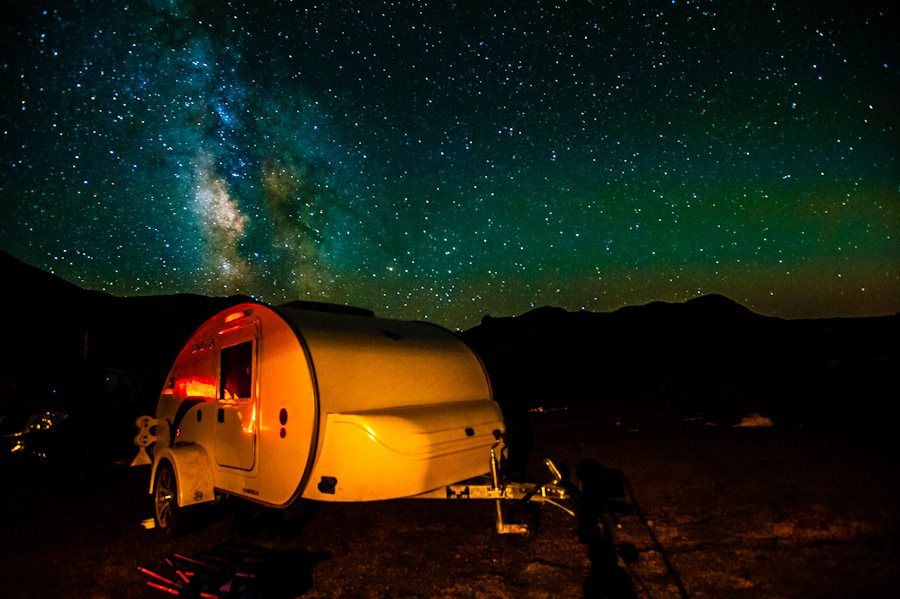 Minicaravana bajo un cielo nocturno repleto de estrellas
