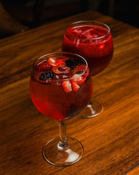 Copas de cócteles rojos con frutos rojos frescos en La Vaca Argentina Plaza Picacho.