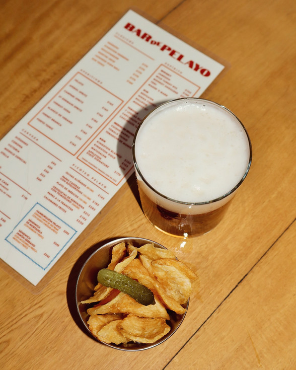 Cerveza con papas fritas y menú sobre mesa en Res Pública Zapopan.