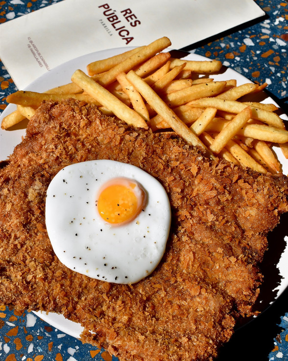 Milanesa con huevo estrellado y papas fritas en Res Pública Zapopan.