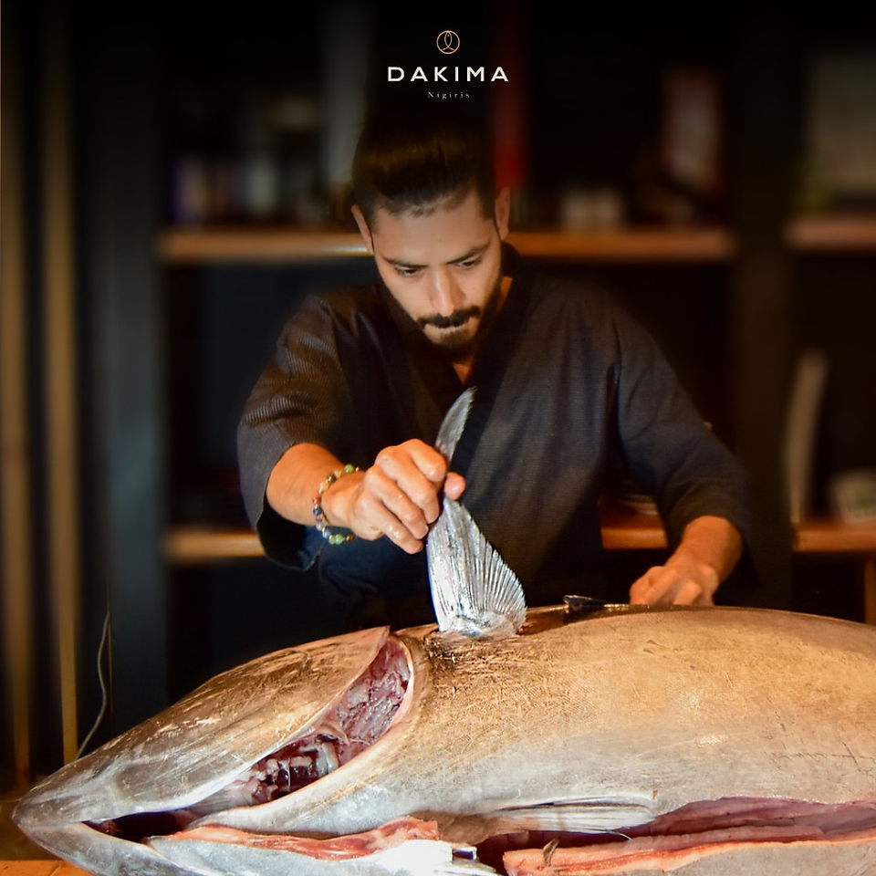 Chef fileteando atún fresco en cocina de Dakima restaurante.