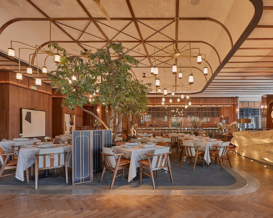 Interior de Sylvestre Midtown con mesas y árboles decorativos