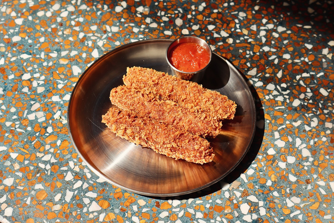 Entrada de empanizado crujiente con salsa roja en Res Pública Zapopan.