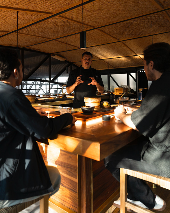 Chef atendiendo mesa de comensales en Omigoto restaurante.