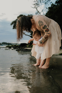 a mum and her toddler playing at the beach during a golden hour family photography session in the sutherland shire