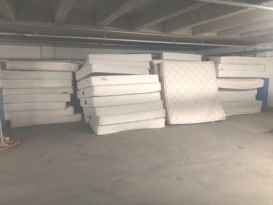 Stack of mattresses and box springs in a hotel parking garage that was cleaned out by SLC Junk