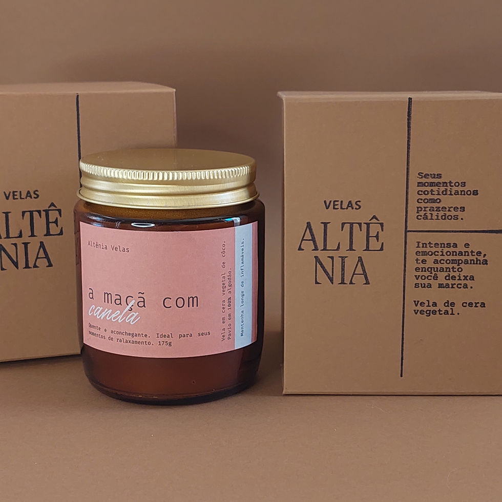 Miniatura: Vela aromática em vidro âmbar com tampa dourada. Vela de 175 g com fragrância de maçã com canela. Apresentada em caixa cartonada marrom  e etiqueta rosa amarronzado. 