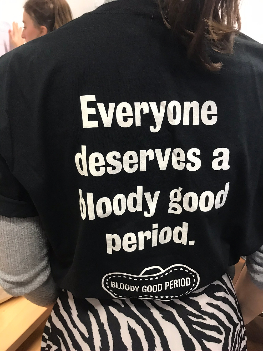 Woman wearing a T-shirt which reads 'Everyone deserves a bloody good period'