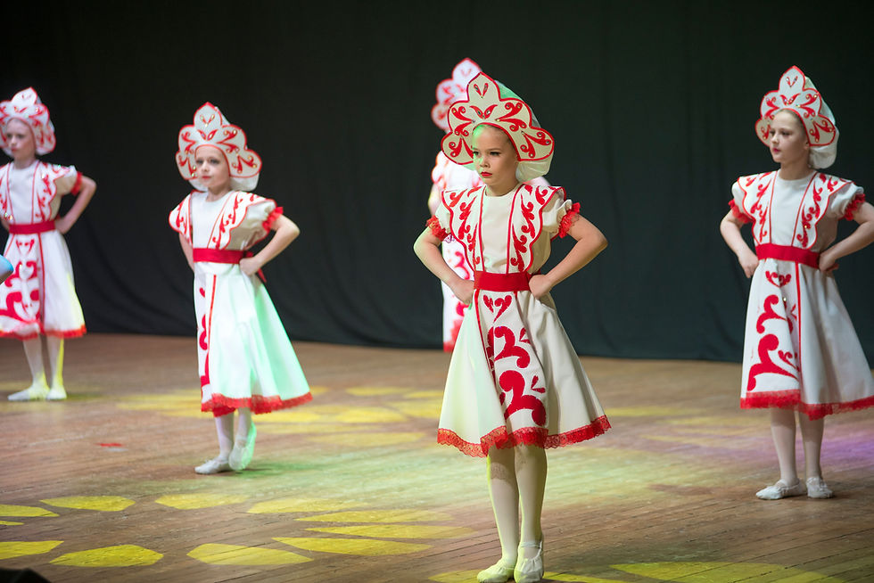 Young dancers performing together on stage in matching costumes.