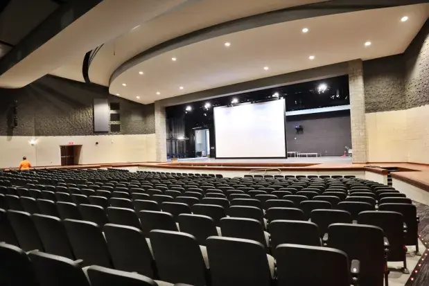 High angle view of a large dance hall with bright stage lights and ample seating