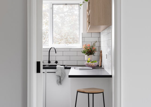 a kitchen with white cabinets and a black sink