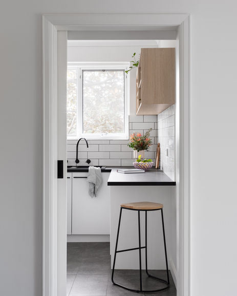 a kitchen with white cabinets and a black sink