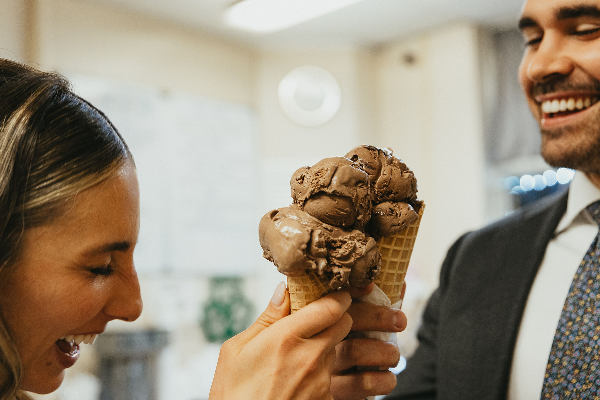 Laughing newlywed couple sharing ice cream with each other