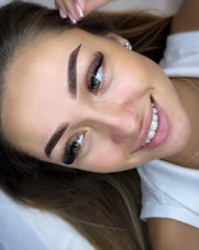 Woman smiling after microblading brows and individual lash extensions at The Look Salon Pretoria.
