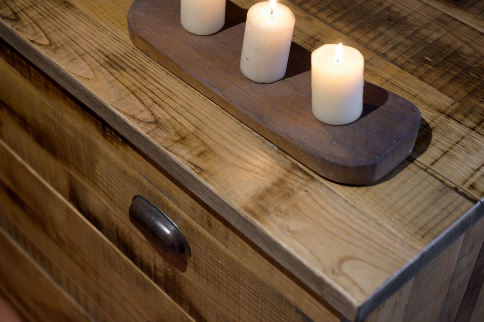 Reclaimed wood dresser with metal cup pull hardware and concrete candle holder with three lit pillar candles, Appartamento Montepulciano, Tuscany