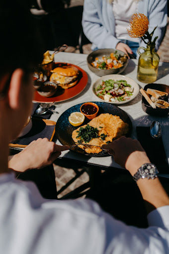 Sonnige Terrasse des Restaurants Charles am Hauptplatz Villach mit mediterranem Flair.