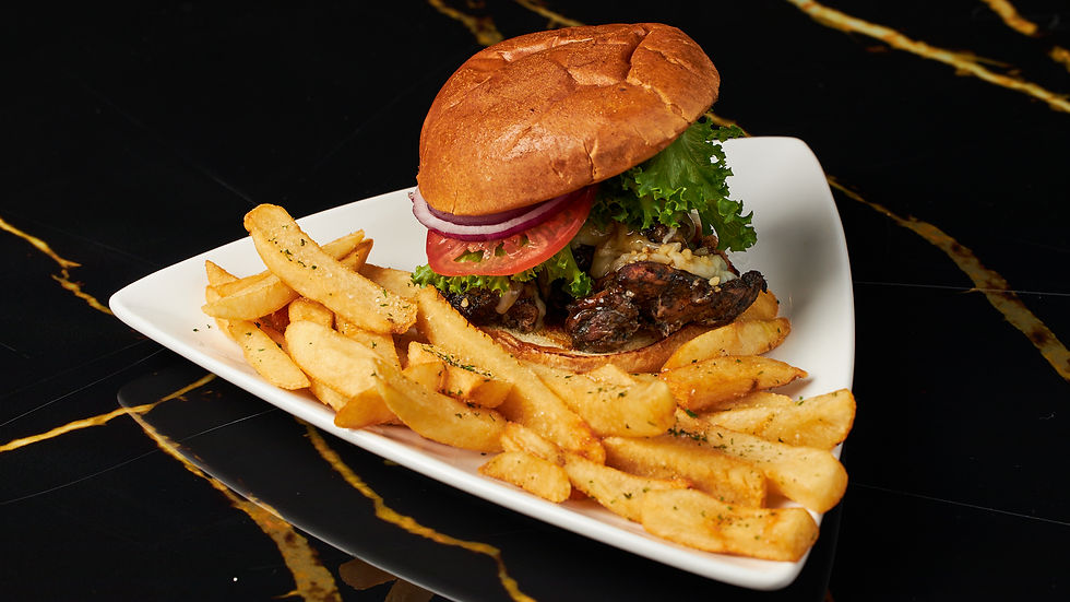 Safari Restaurant & Bar burger served with seasoned fries on a white plate in Atlanta’s West End.