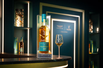 格蘭菲迪威士忌瓶與酒杯,置於時尚的吧台,作為室內設計推薦