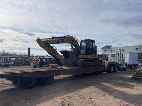 CAT excavator transport on lowboy trailer - heavy equipment hauling by ABC crating & Rigging