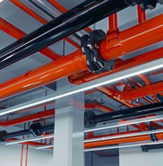 Várias tubulações pretas e laranjas em um teto, Soluvendas.