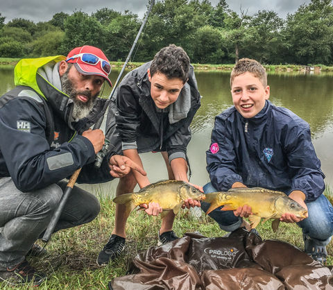 Trois jeunes pêcheurs avec leurs carpes