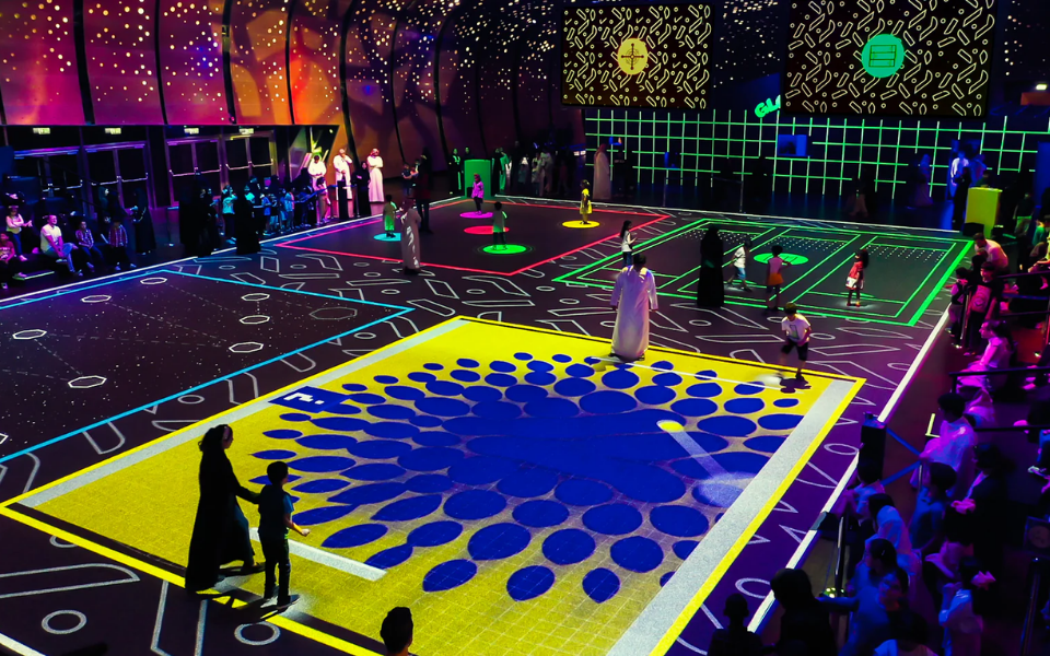 Large indoor interactive floor experience with families playing on multiple projected game zones
