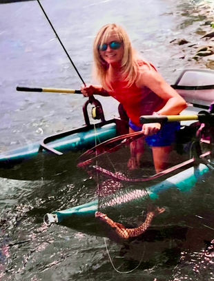 An angler shows off her catch on the Snake River with her Dave Scadden inflatable fishing boat