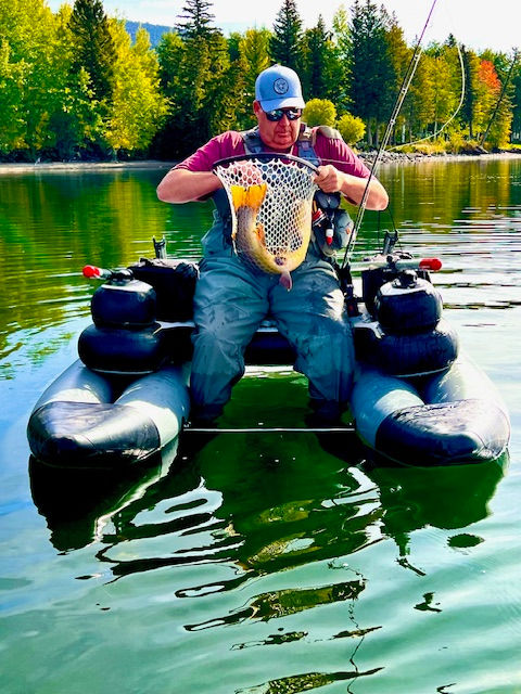 An angler lands a huge Cutbow while fishing Henry's Lake on his Dave Scadden Dagger inflatable fishing boat. A lovely blue sky day on a beautiful lake! Perfect for fishing.
