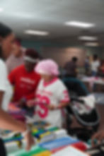 Child receiving a backpack during The Greatest Commandment Inc. Back-to-School Drive in Orlando 2025.