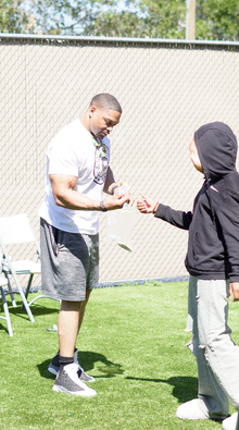 Volunteer handing Easter basket to homeless child during The Greatest Commandment Inc. Easter Event in Orlando.